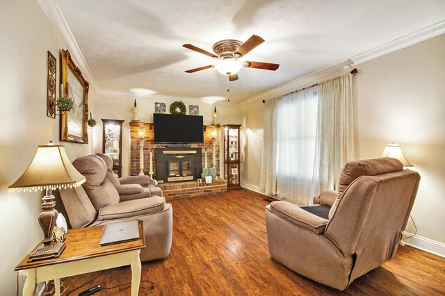 living room with a fireplace, dark wood-type flooring, ornamental molding, ceiling fan, and baseboards