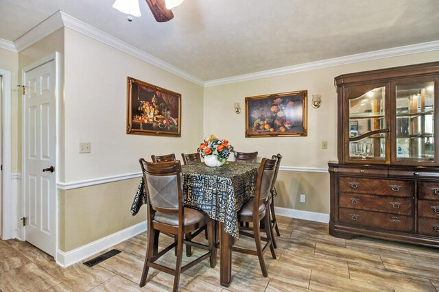 dining area with light wood finished floors, visible vents, ornamental molding, ceiling fan, and baseboards