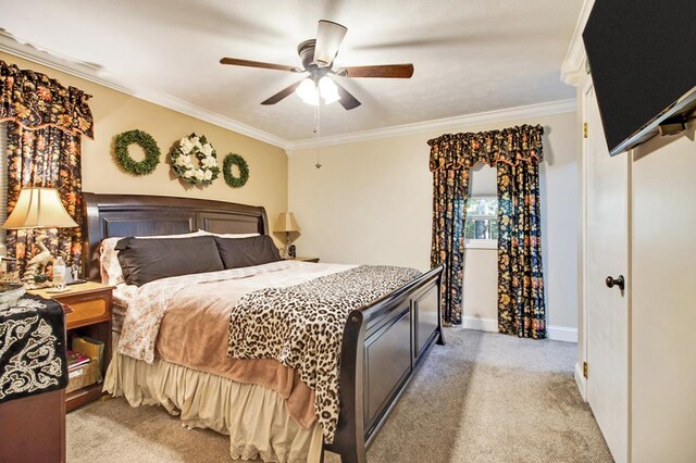 bedroom featuring baseboards, ornamental molding, a ceiling fan, and light colored carpet