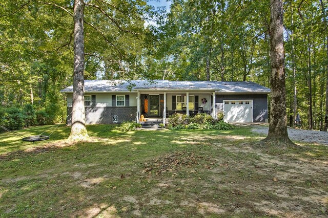 ranch-style house with an attached garage, covered porch, a front yard, and brick siding