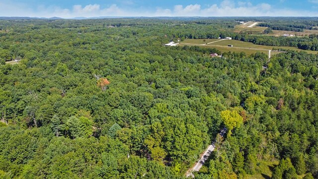 drone / aerial view featuring a wooded view