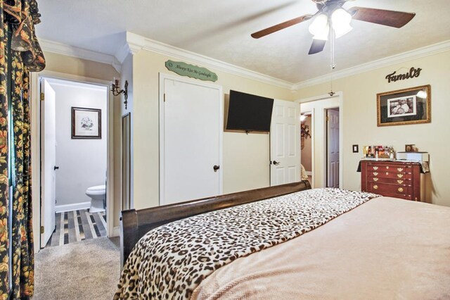 bedroom featuring a ceiling fan, carpet flooring, crown molding, and ensuite bath