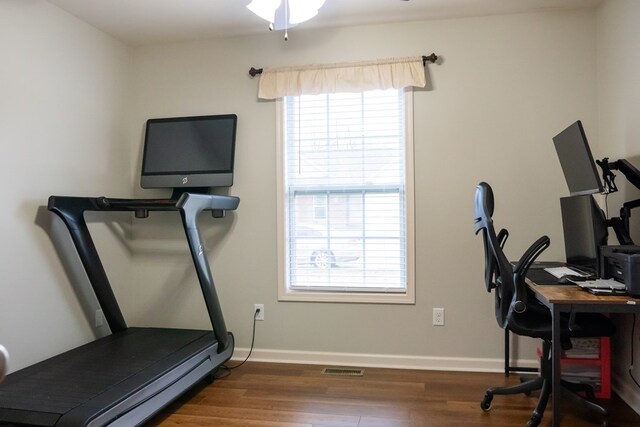 interior space with dark wood-style floors, ceiling fan, visible vents, and baseboards