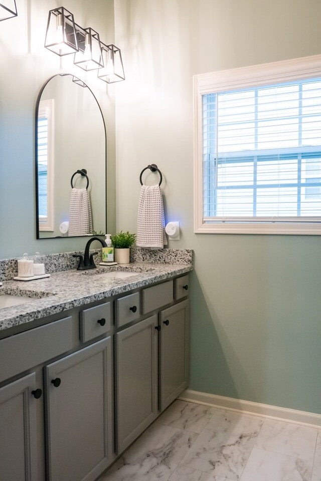 bathroom featuring marble finish floor, vanity, and baseboards