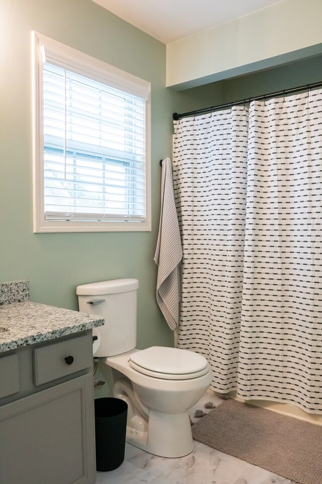 full bathroom with marble finish floor, vanity, toilet, and a shower with curtain