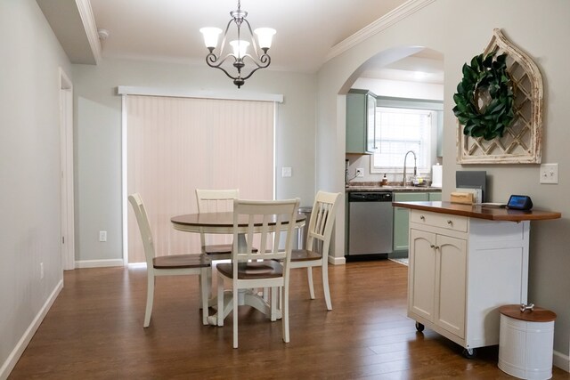 dining area with arched walkways, a chandelier, dark wood-type flooring, baseboards, and crown molding