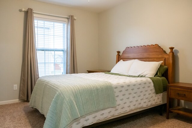 bedroom featuring light colored carpet and baseboards