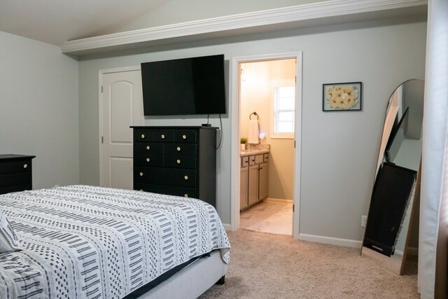 bedroom featuring light colored carpet, baseboards, and ensuite bathroom