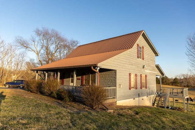 view of property exterior featuring crawl space, metal roof, and a yard