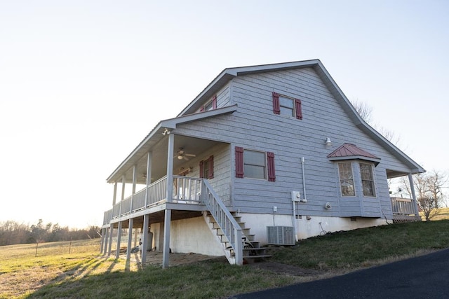 exterior space featuring a lawn, cooling unit, stairs, and ceiling fan