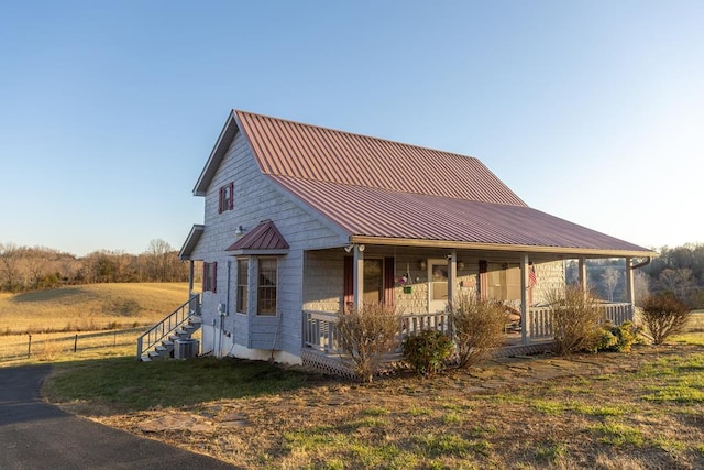 view of front facade featuring metal roof, a porch, and a standing seam roof