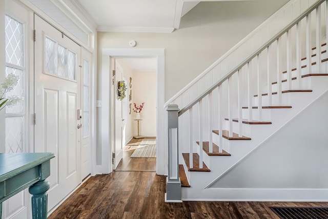 entrance foyer featuring dark wood-style floors, crown molding, stairway, and baseboards