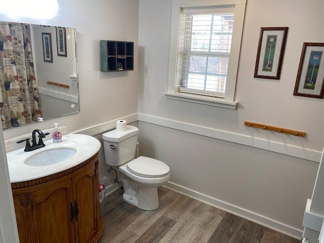 full bathroom with vanity, toilet, and wood finished floors