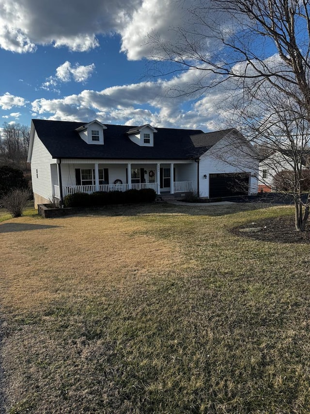 view of front of home with a garage, covered porch, and a front lawn