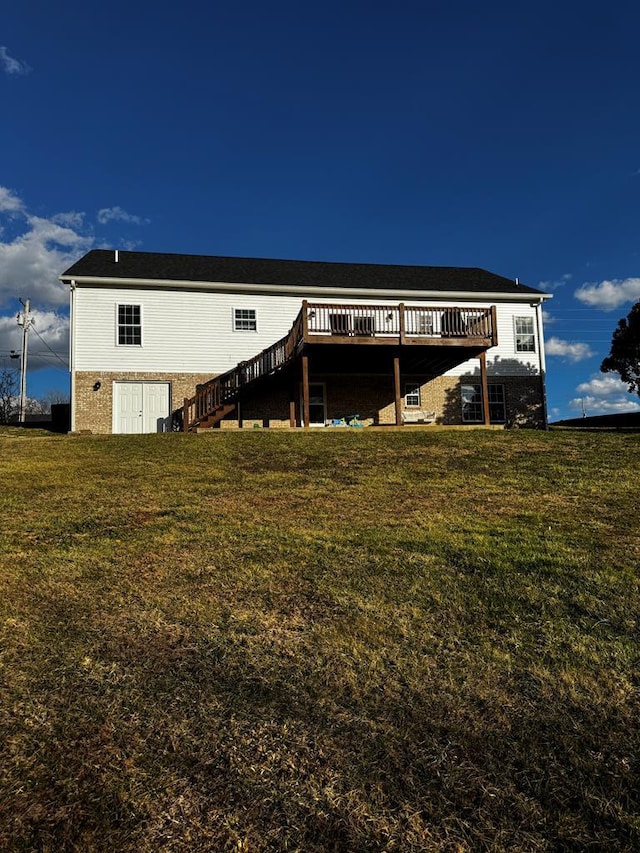 rear view of house with a deck, a lawn, and stairway