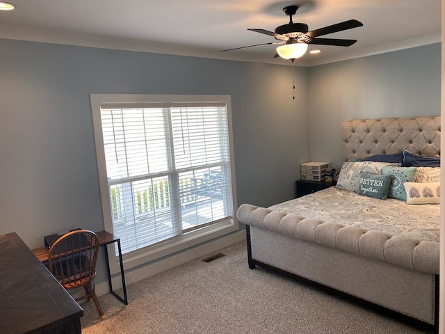 carpeted bedroom with a ceiling fan, visible vents, and crown molding