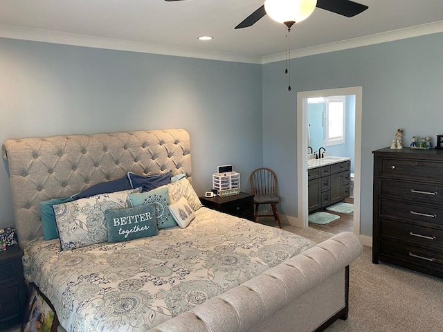 bedroom featuring carpet floors, a sink, baseboards, ornamental molding, and ensuite bath