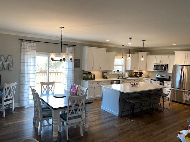 kitchen with appliances with stainless steel finishes, a center island, crown molding, and a sink