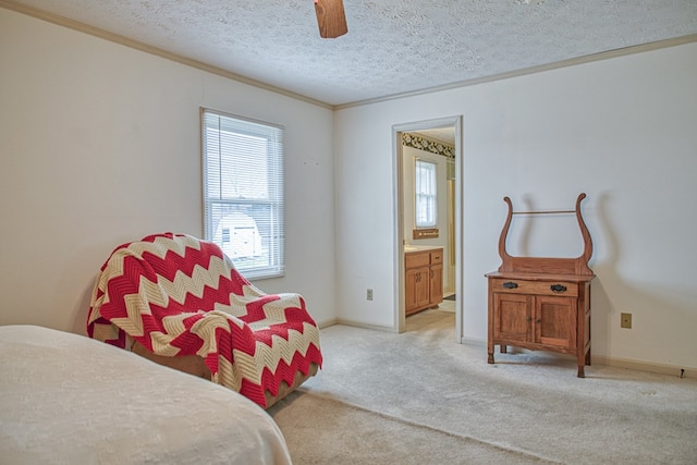 bedroom featuring baseboards, light colored carpet, ornamental molding, ensuite bathroom, and a textured ceiling