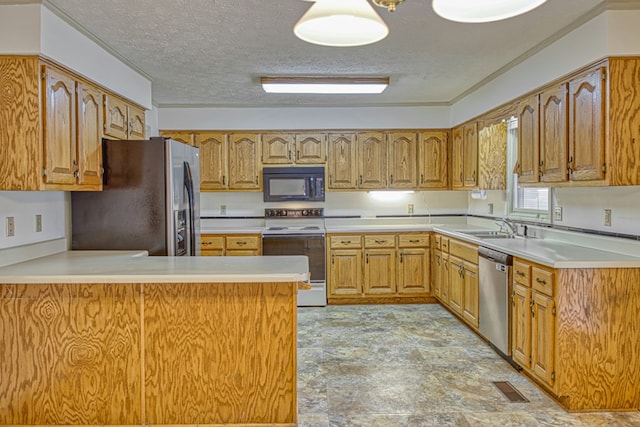 kitchen with light countertops, visible vents, appliances with stainless steel finishes, a sink, and a peninsula