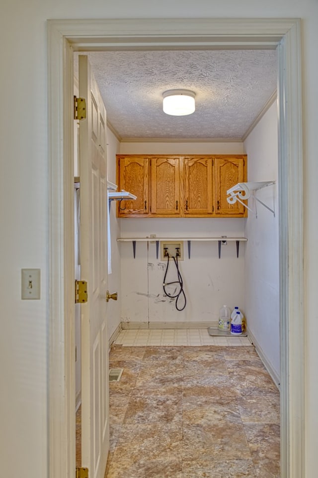 clothes washing area featuring laundry area, crown molding, washer hookup, and a textured ceiling