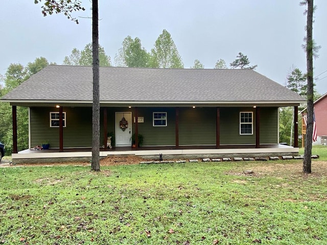 view of front facade featuring a front yard and roof with shingles