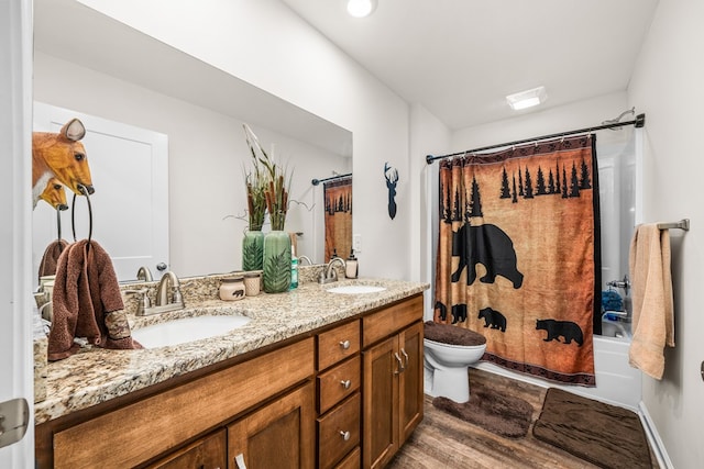 bathroom with toilet, shower / bathtub combination with curtain, double vanity, and a sink