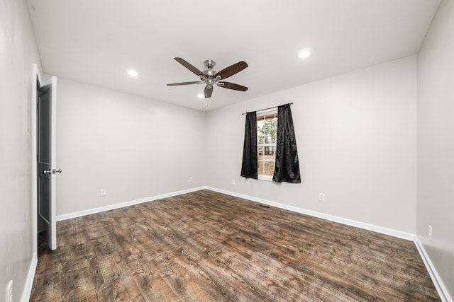 empty room featuring baseboards, dark wood-style flooring, and recessed lighting