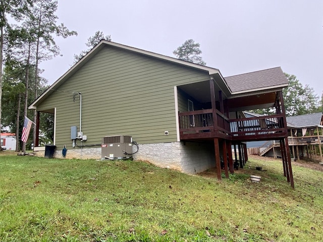 view of side of property featuring a lawn, roof with shingles, crawl space, stairs, and central AC