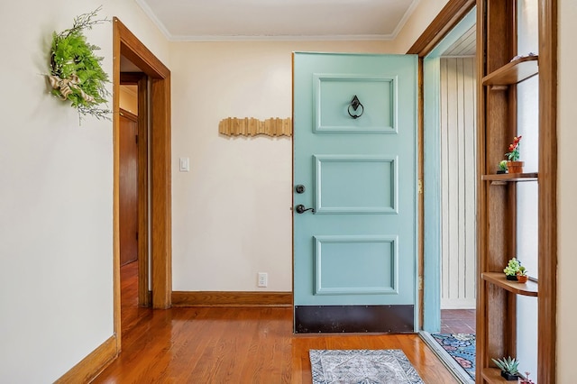 interior space with baseboards, crown molding, and wood finished floors