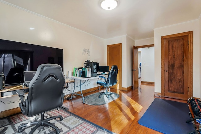 office space featuring baseboards, ornamental molding, and wood finished floors