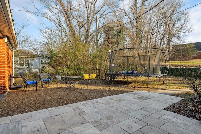 exterior space featuring a trampoline and fence