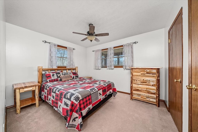 carpeted bedroom with a ceiling fan, a textured ceiling, and baseboards