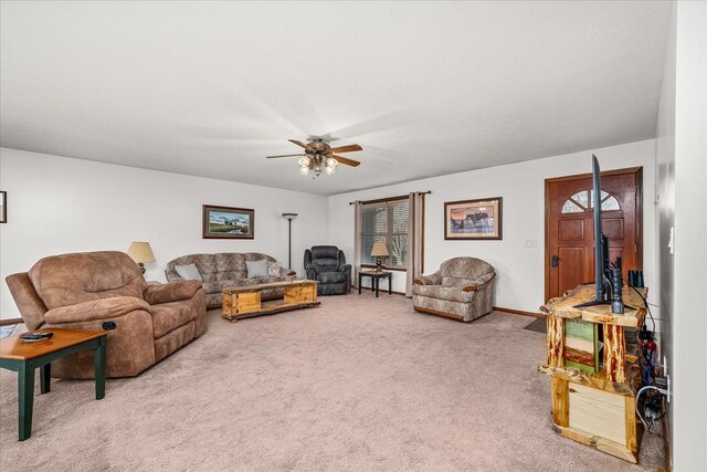 living area featuring ceiling fan, carpet floors, and baseboards