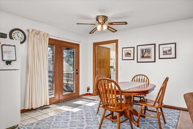 dining room with french doors, ceiling fan, baseboards, and light tile patterned floors