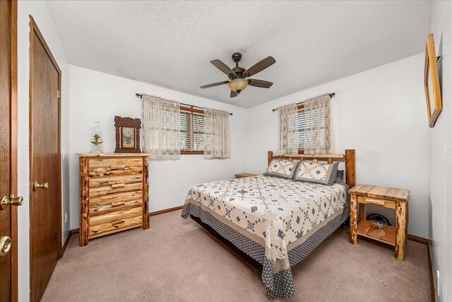 bedroom with ceiling fan, baseboards, and light colored carpet