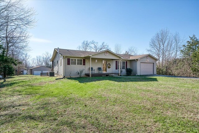 single story home featuring a garage, covered porch, and a front lawn