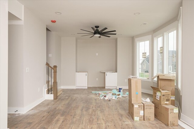 spare room featuring baseboards, light wood finished floors, and stairs