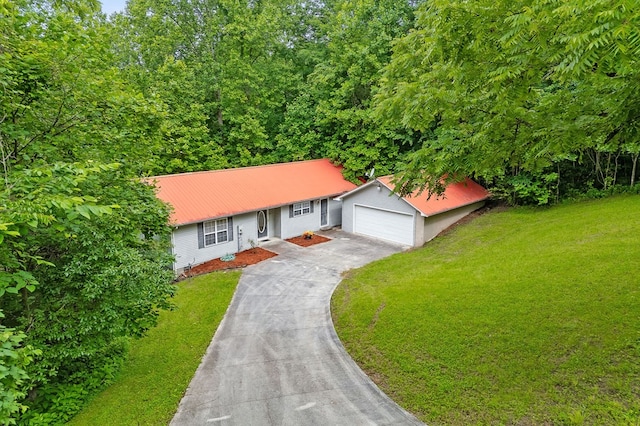 view of front of home featuring a garage, a front yard, metal roof, and driveway