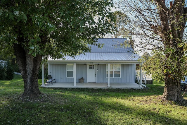 view of front of property with metal roof, a front lawn, and a patio