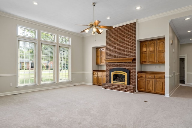 unfurnished living room featuring a brick fireplace, crown molding, and light colored carpet