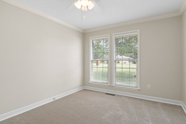 carpeted empty room featuring ornamental molding, a wealth of natural light, visible vents, and baseboards