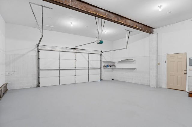 garage with concrete block wall and a garage door opener