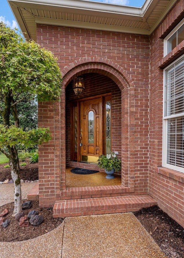 doorway to property featuring brick siding