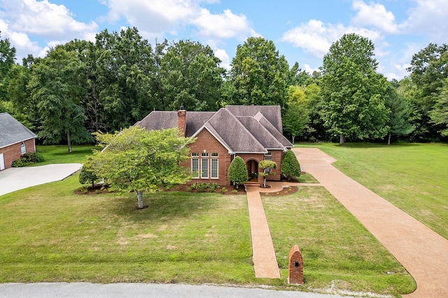 traditional home featuring brick siding, a chimney, and a front yard