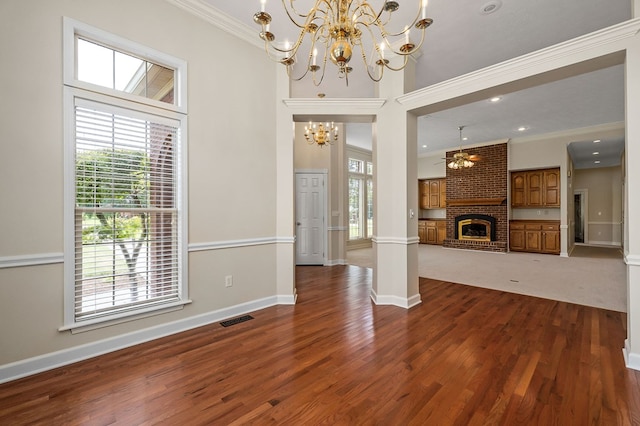 unfurnished living room featuring ornamental molding, a chandelier, visible vents, and a fireplace