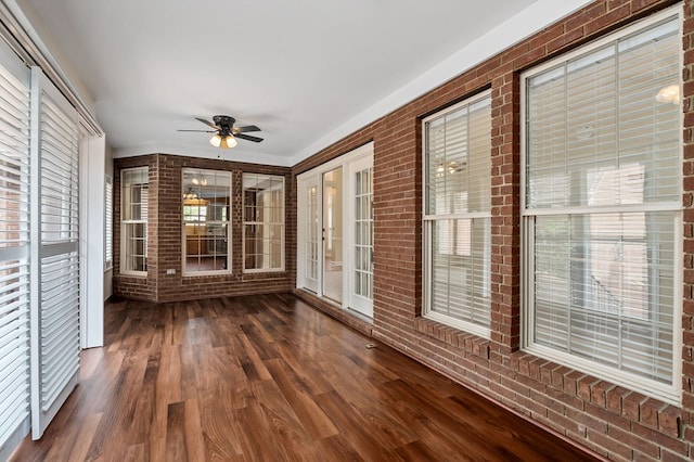 unfurnished sunroom featuring ceiling fan