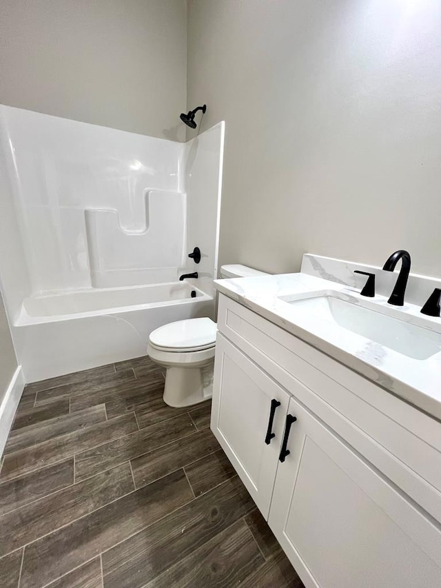 full bath with toilet, vanity,  shower combination, and wood finish floors