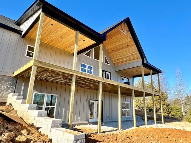 rear view of property with roof with shingles and board and batten siding