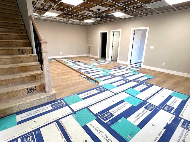 below grade area featuring stairway, visible vents, baseboards, and wood finished floors